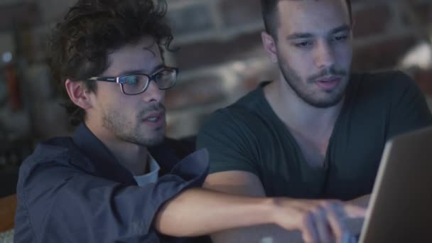 Dos estudiantes están teniendo una discusión al lado de una computadora portátil en una habitación . — Vídeo de stock