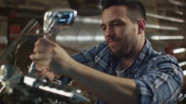 Adam bir anahtar ile somun sıkma ve onun motosiklet bir garajda onarma.