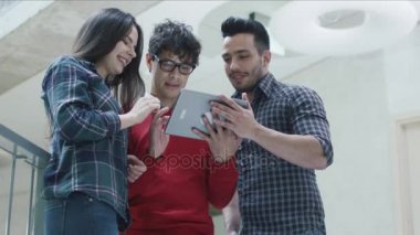 Grup genç çok etnik gruptan oluşan öğrenci bir üniversitede bir tablet bilgisayar kullanıyorsanız.