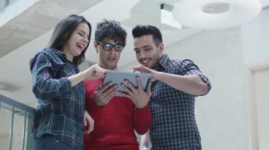 Grup genç çok etnik gruptan oluşan öğrenci bir üniversitede bir tablet bilgisayar kullanıyorsanız.