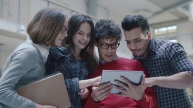 Grup genç çok etnik gruptan oluşan öğrenci bir üniversitede bir tablet bilgisayar kullanıyorsanız.