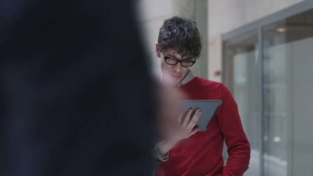 Пара студентов пользуются планшетным компьютером в университете . — стоковое видео