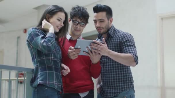 Un gruppo di giovani studenti multietnici utilizza un tablet in un'università . — Video Stock