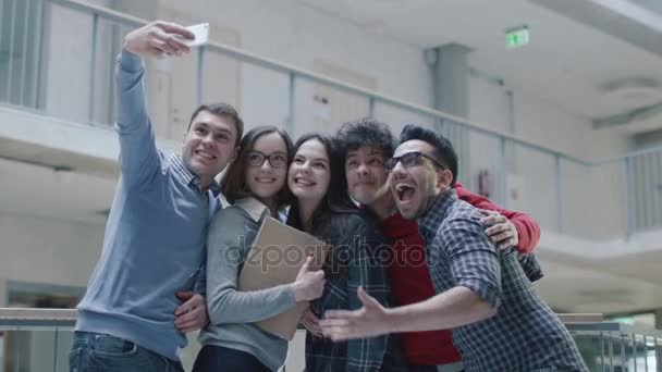 Grupp unga multietniska studenter gör selfie foton i ett universitet. — Stockvideo