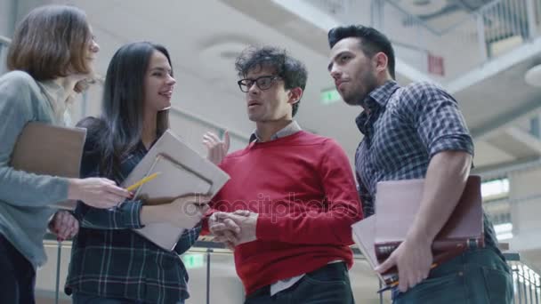 Un groupe de jeunes étudiants multiethniques discutent dans un lobby universitaire . — Video