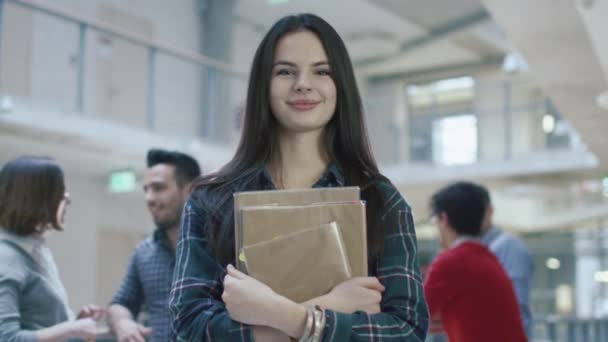 Retrato de una joven estudiante morena bonita en un pasillo de la escuela secundaria . — Vídeos de Stock