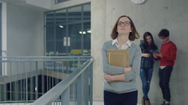 Porträtt av en ung student flicka promenader med böcker i en university Hall. — Stockvideo