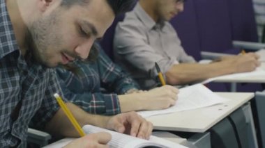 Görüntüleri öğrencilerin ders sırasında bir kolaj sınıfında kağıt kalem ile yazma.