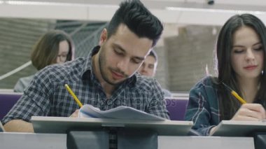 Görüntüleri latin öğrencinin ders sırasında bir kolaj sınıfında kağıt kalemle yazma.