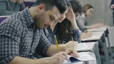 Görüntüleri İspanyol öğrenci ders sırasında bir kolaj sınıfında kağıt kalemle yazma.