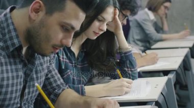 Görüntüleri öğrencilerin ders sırasında bir kolaj sınıfında kağıt kalem ile yazma.