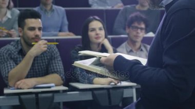 Üniversite profesörü bir kitap tutarken çok etnik gruptan oluşan öğrenciden oluşan bir sınıfta öğretim.