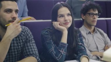 Üniversite profesörü bir kitap tutarken çok etnik gruptan oluşan öğrenciden oluşan bir sınıfta öğretim.
