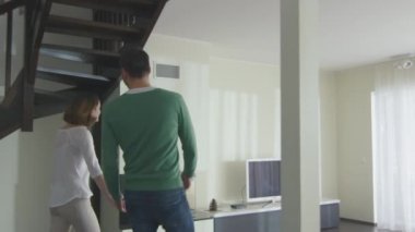 Mutlu bir çift yeni bir ev yürüyüş ve evin çevresinde arıyorsunuz.