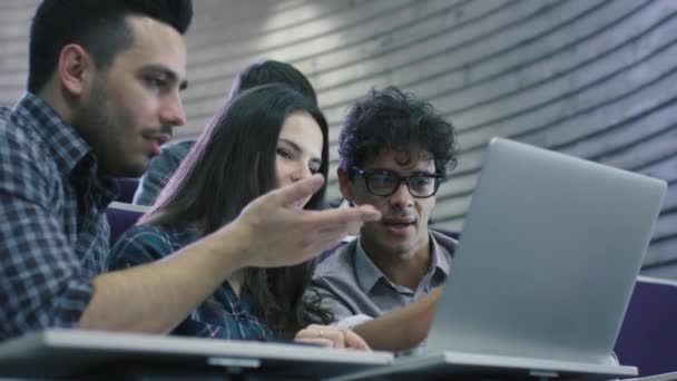 Női és férfi tanulócsoport ül a főiskolán tantermi és látszó-on egy laptop számítógép. — Stock videók