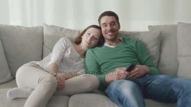 Çift evde kanepede oturan ve tv izlerken.