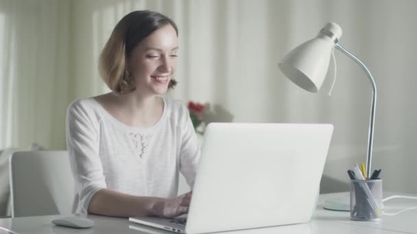 Žena pracuje na přenosný počítač doma a zjistí, že má získala cenu. — Stock video