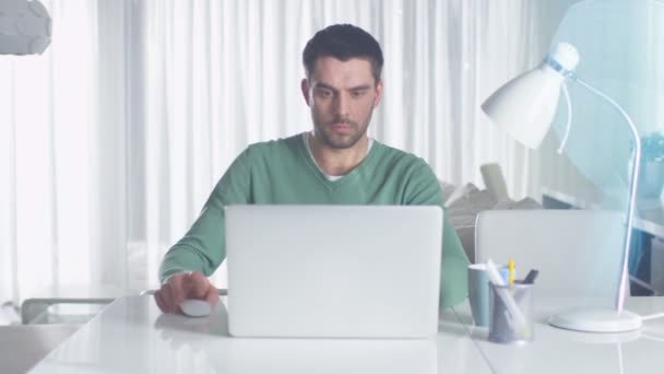 男は、ラップトップ コンピューターを自宅に取り組んでいます。. — ストック動画