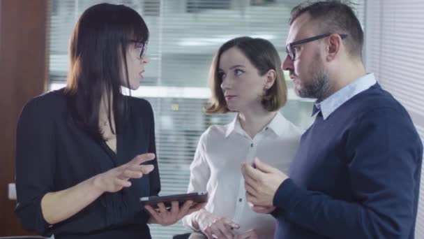 Grupo de empleados están teniendo una conversación en la sala de reuniones. Businesswoman está usando una tableta . — Vídeos de Stock