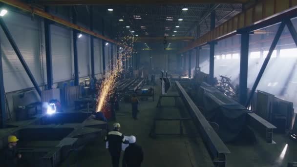 Images d'une usine de l'industrie lourde avec des travailleurs et des étincelles volantes . — Video