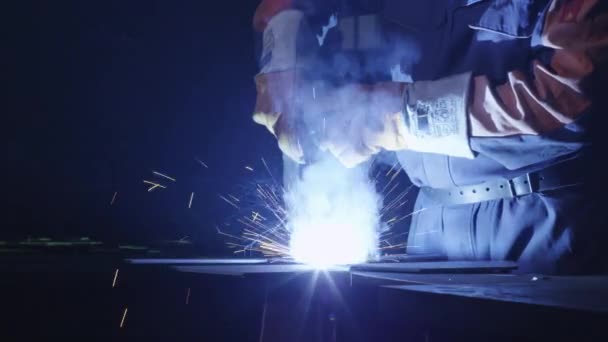 Trabajador de la industria pesada en una fábrica está soldando metal en el interior oscuro . — Vídeos de Stock