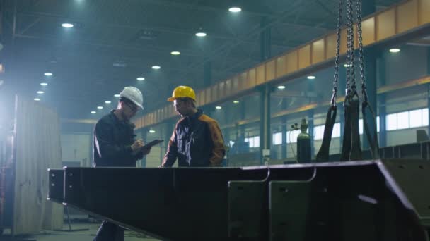 Gerente e ingeniero trabajador en sombreros están teniendo una conversación en una fábrica de la industria pesada . — Vídeo de stock