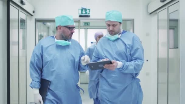 Két orvosok, séta át a kórház és a beszélgető. Tabletta tartja kezében. — Stock videók