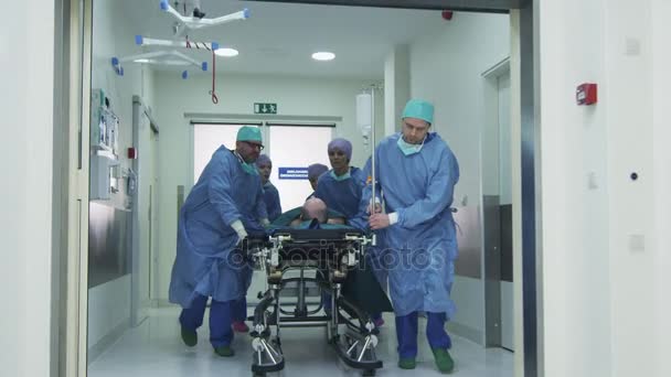 Nemocnice tým nošení nosítka s pacientem prostřednictvím nemocnice Hall — Stock video