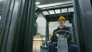 Bir forklift kamyon sürüş bir depo işçisi portresi.