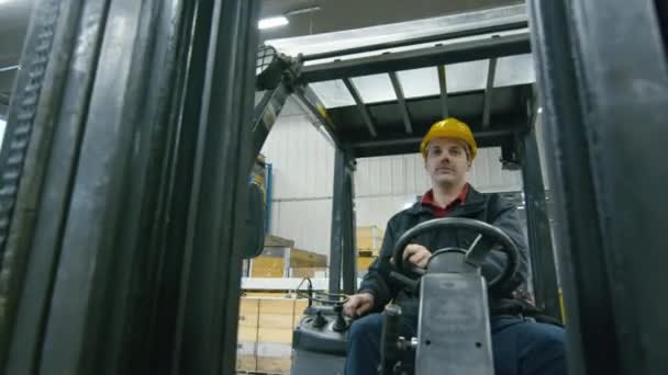 Portrait d'un ouvrier d'entrepôt conduisant un chariot élévateur .