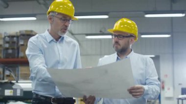 Lojistik merkezi depo, iki çalışanı beyaz kağıt üzerinde planı hakkında konuşmak.