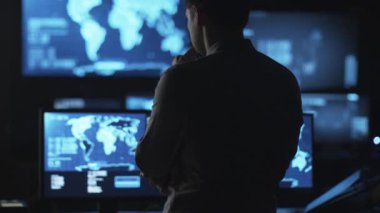 Erkek çalışan bilgisayar ekranları haritalar ve arıyor veri ile oda karanlık ofis sergilenen BT.