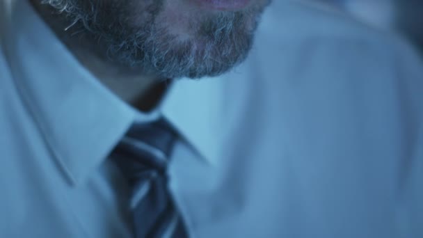 Manager is working on a computer in the evening in a dark office room filled with display screens. — Stock Video