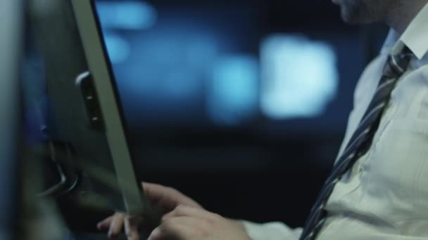 Programmeur professionnel de l'informatique travaille sur l'ordinateur dans la salle de bureau sombre remplie d'écrans d'affichage .