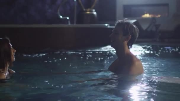 Junges Paar schwimmt in einem Pool in einem Wellness-Center. — Stockvideo