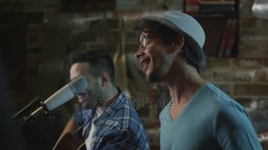 İki genç adam şarkı ve ev stüdyosunda bir garaj bir şarkıda prova yaparken gitar çalmak.