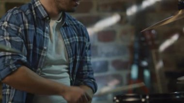 Davulcu ev stüdyosunda bir garaj bir şarkıda prova yaparken müzik çalar.