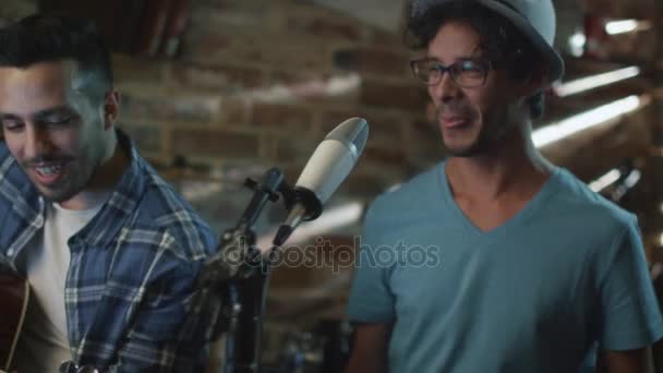Banda cantar y tocar guitarras mientras graba una canción y practicar en un estudio en casa en un garaje . — Vídeos de Stock