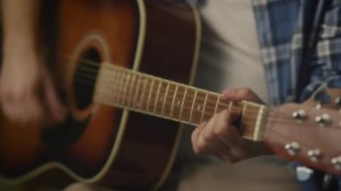Ev stüdyosunda bir garaj bir şarkıda prova yaparken adam gitar çalıyor.