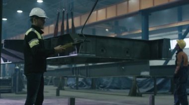 Ağır sanayi işçileri bir fabrikada bir büyük metal inşaat detay hareket ediyor.