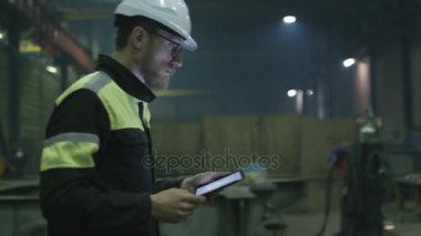 Kask mühendisi bir ağır sanayi Fabrikası ile bir tablet bilgisayar üzerinden hareket ediyor.