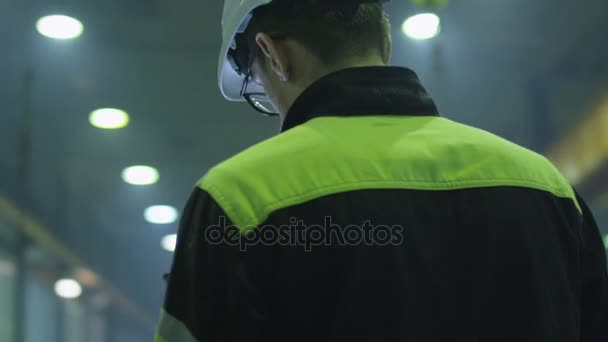 Μηχανικός στο hardhat κρατά έναν υπολογιστή tablet σε ένα εργοστάσιο της βαριάς βιομηχανίας. — Αρχείο Βίντεο