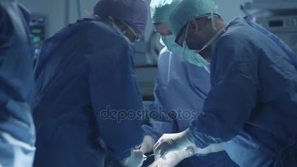 Equipo médico realizando operación quirúrgica en quirófano moderno — Vídeos de Stock