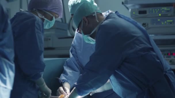 Equipo médico realizando operación quirúrgica en quirófano moderno — Vídeo de stock