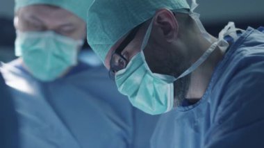 Modern ameliyathanede cerrahi operasyonu odaklı ve konsantre cerrah portresi.