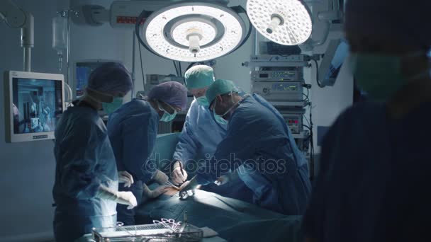 Zespół medyczny wykonujący operacje chirurgiczne na nowoczesnej sali operacyjnej — Wideo stockowe