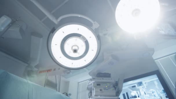 Allumage des lumières en salle d'opération. Équipe de médecins et d'infirmières sur le patient. Point de vue du patient . — Video