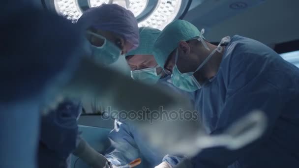 Equipe médica realizando operação cirúrgica na sala de cirurgia moderna — Vídeo de Stock