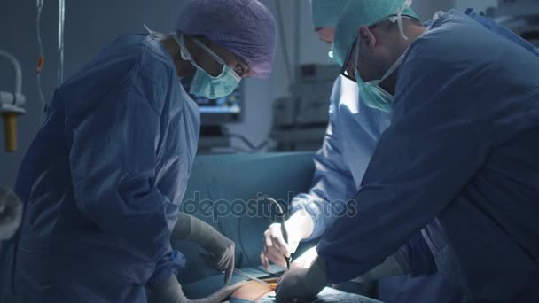 Tıbbi ekip modern ameliyathanede cerrahi operasyon yapıyor. — Stok video