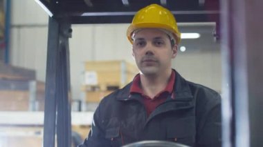 Bir forklift kamyon sürüş bir depo işçisi portresi.